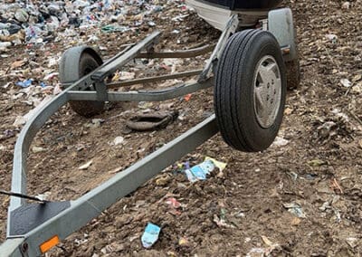 boat being dropped off a trailer at landfill